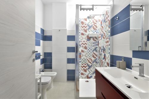 バリ・サルドにあるAppartamentinoの青と白の壁とトイレと洗面台のあるバスルーム