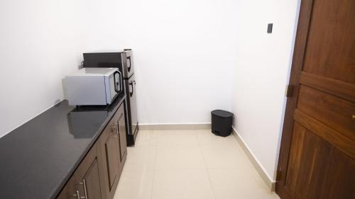 a kitchen with a microwave on a black counter at JAMUNA VILLA in Jaffna
