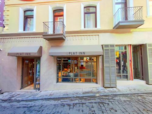 una tienda frente a un edificio con ventanas y balcones en Plat Inn Hotel Taksim, en Estambul