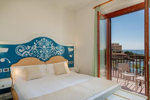 a bedroom with a bed and a balcony at Hotel El Balear in Alghero