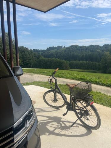a bike parked on a sidewalk next to a car at Sunhand home in Eibiswald