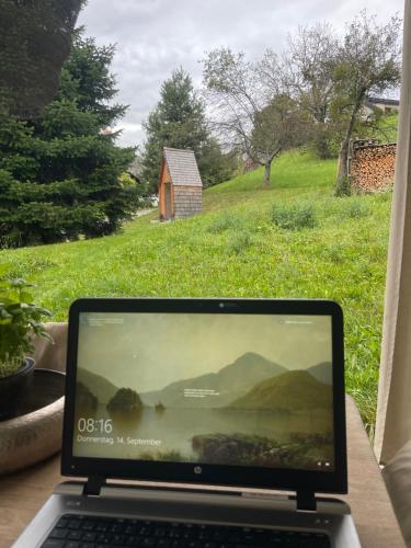 a laptop computer sitting on a table next to a window at Sunhand home in Eibiswald