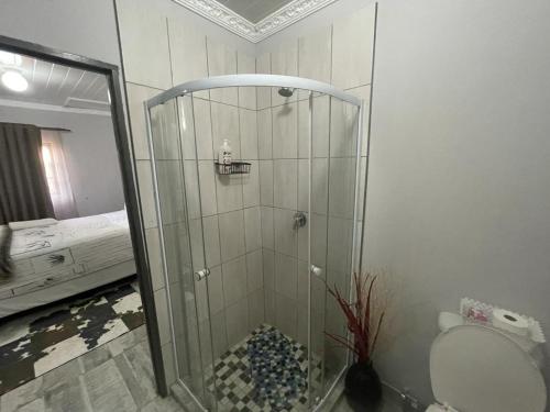 een badkamer met een douche, een toilet en een bed bij OlimG Stays1 in East London