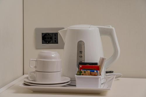 a white tea kettle and cups on a table at Hotel El Balear in Alghero