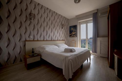 a bedroom with a bed and a large window at Hotel Frejus in Collegno