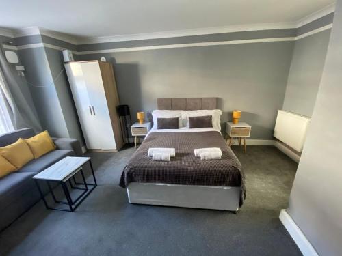 a bedroom with a bed and a couch at Gravesend 1 Bedroom Apartment 2 Min Walk to Station - longer stays available in Gravesend