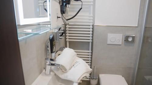 een badkamer met een wastafel, een toilet en een spiegel bij Hotel Busch in Gütersloh