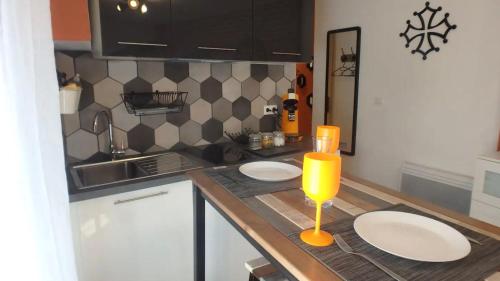 - une cuisine avec 2 plaques blanches et 2 bougies sur un comptoir dans l'établissement Barberina - Studio en centre ville, à Toulouse