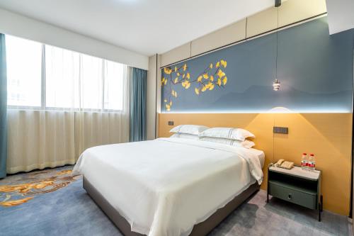 a bedroom with a large bed and a painting on the wall at WAIFIDEN Hotel -Former Tokai Hotel - Xiaobei Metro Station - During the Canton Fair, there will be shuttle buses for transportation back and forth in Guangzhou