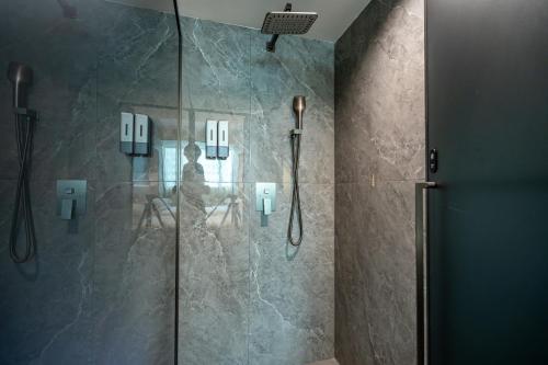 a bathroom with a shower with a glass door at WAIFIDEN Hotel -Former Tokai Hotel - Xiaobei Metro Station - During the Canton Fair, there will be shuttle buses for transportation back and forth in Guangzhou