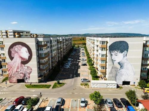 a parking lot with cars parked in front of buildings at Warm Apartament Nou in Bacău
