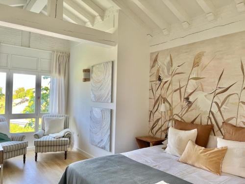 a bedroom with a bed and a large painting on the wall at Wishome-Casa con bonito jardín y piscina, ideal para familias, cerca de Comillas in Prellezo