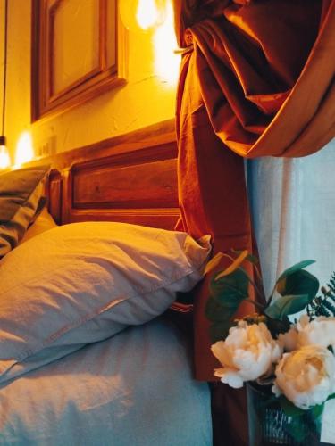 a bed with a headboard and a vase with flowers at Arte i Espacio Home in Madrid