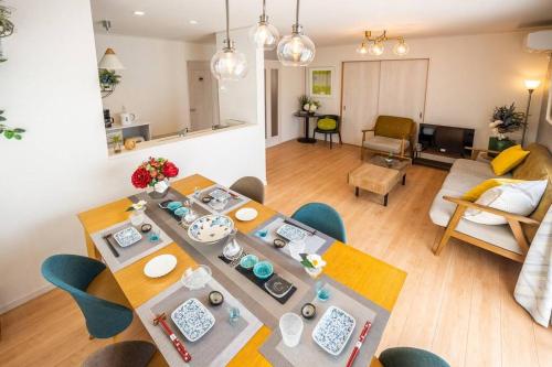 a dining room and living room with a table and chairs at 最大12人築浅物件 南部を満喫したい方におすすめ 無料駐車場2台 リージュアリーハウス in Inamine