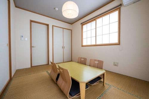 a room with a table and chairs and a window at 最大12人築浅物件 南部を満喫したい方におすすめ 無料駐車場2台 リージュアリーハウス in Inamine
