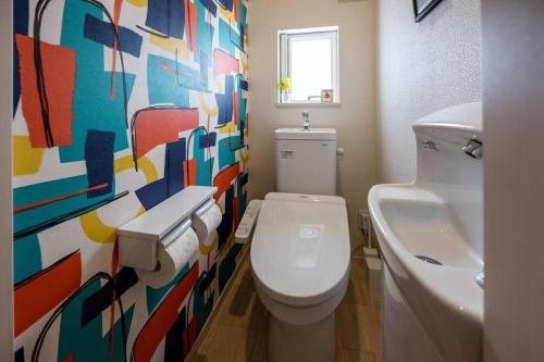 a bathroom with a white toilet and a sink at 最大12人築浅物件 南部を満喫したい方におすすめ 無料駐車場2台 リージュアリーハウス in Inamine