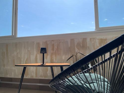 a table with a lamp on it next to a chair at ZELUN Suite Torremolinos Center in Torremolinos