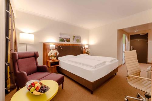 Habitación de hotel con cama y silla en PLAZA Premium Wien en Viena
