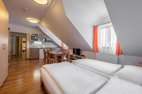 Cet appartement comprend une chambre avec un lit et une cuisine avec une table. dans l'établissement Penzion Terezka, à Dolní Morava