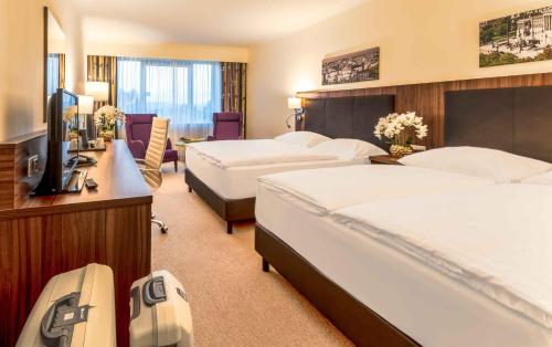 a hotel room with two beds and a television at PLAZA Premium Wien in Vienna
