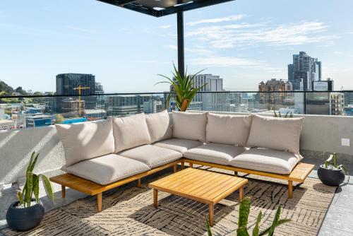 ein Sofa auf einem Balkon mit Stadtblick in der Unterkunft The Tokyo Aparthotel by Totalstay in Kapstadt