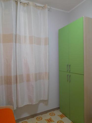 a room with a green cabinet and a curtain at Casa Vacanza Marano in Mascali
