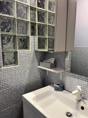 baño con lavabo blanco y armario en Matilda’s Apartment, en Strambino