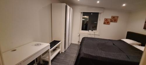 - une chambre avec un lit, un bureau et une fenêtre dans l'établissement lägenhet, à Göteborg