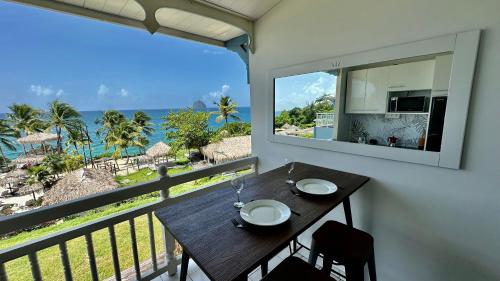 a balcony with a table and a view of the ocean at Studio 514 in Le Diamant