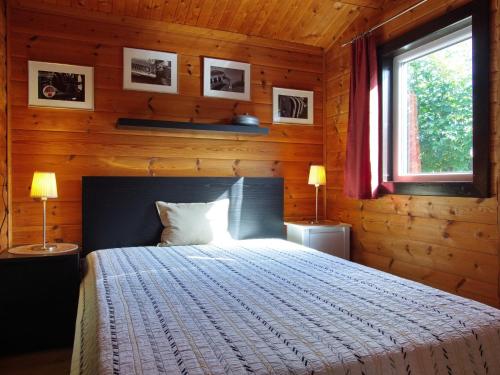 um quarto com uma cama num chalé de madeira em Diemelsee Sudeck - Ein Ferienhäuschen zum WOHLFÜHLEN em Diemelsee