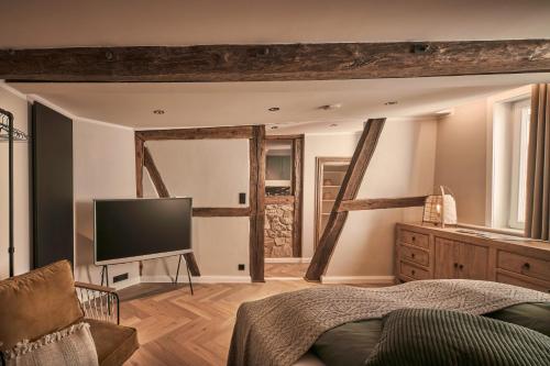 a bedroom with a bed and a flat screen tv at Loft 1540 - Boutique Ferienwohnungen in Fulda