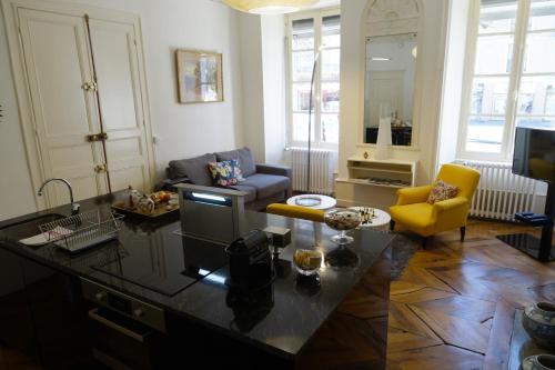 ein Wohnzimmer mit einem Tisch und gelben Stühlen in der Unterkunft Maison Eugénie in Luchon