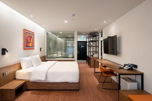 1 dormitorio con 1 cama grande y escritorio en Hotel Cielo, en Siheung