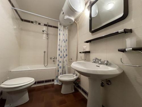 een badkamer met een wastafel, een toilet en een wastafel bij 044 Trilocale, Pinzolo in Pinzolo