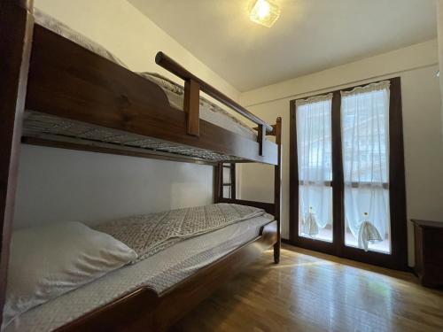 een slaapkamer met 2 stapelbedden en een raam bij 044 Trilocale, Pinzolo in Pinzolo