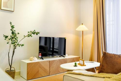 a living room with a flat screen tv on a cabinet at 10 min to My town family unit By Nexx Field in Kuala Lumpur