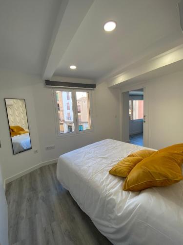 1 dormitorio con 1 cama con 2 almohadas en Apartamentos San Martín, en Plasencia