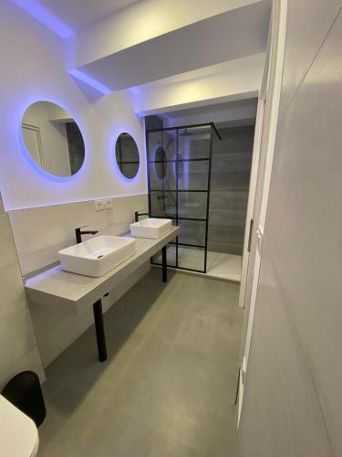 Baño con 2 lavabos y espejo en Apartamentos San Martín, en Plasencia