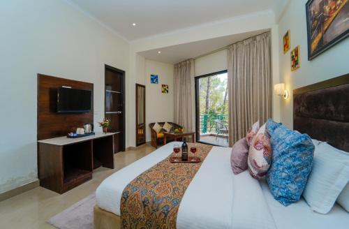 1 dormitorio con 1 cama grande y TV en The Rose, Kasauli -A Four Star Lavish & Luxury Hotel, en Kasauli