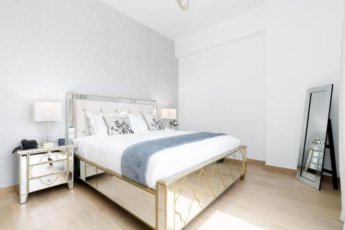a bedroom with a large bed and a mirror at Ultimate Stay Port de La Mer with Burj Khalifa Views from the Bed next to the Beach in Dubai