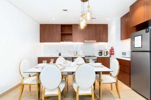 a kitchen and dining room with a table and chairs at Ultimate Stay Port de La Mer with Burj Khalifa Views from the Bed next to the Beach in Dubai