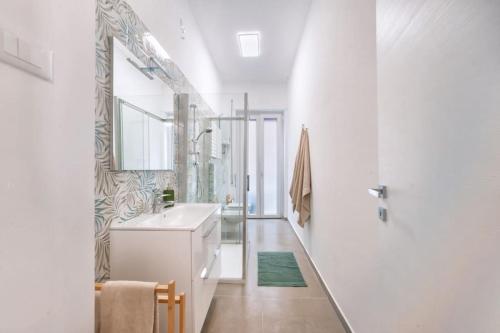 Baño blanco con lavabo y espejo en Blue Horizon, en Pescara