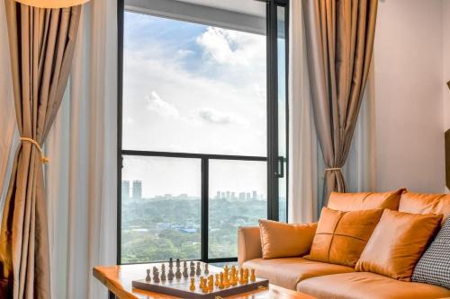 a living room with a couch and a chessboard in front of a window at 10 min to My town family unit By Nexx Field in Kuala Lumpur