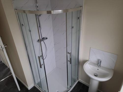 uma casa de banho com um chuveiro, um WC e um lavatório. em Cosy room in a stunning location em Llandrillo-yn-Rhôs