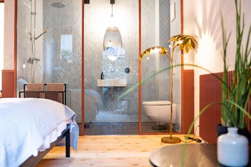 a bedroom with a bed and a bathroom with a toilet at TREMONDI - Boutique BnB in Quarten