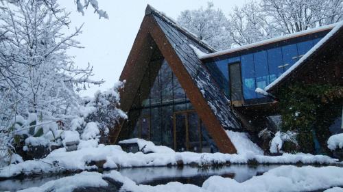 a house with a triangular roof in the snow at SOLAR STROH TRIGON nonAC in Niedermuhlern