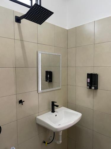 a bathroom with a sink and a mirror at Arifz Zai Homestay in Batu Kurau
