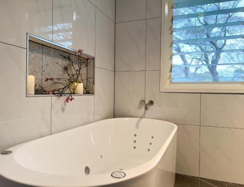 a white bath tub in a bathroom with a window at Birdwood Guesthouse in Blackheath