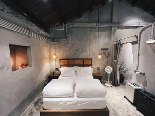 1 dormitorio con 1 cama grande con sábanas blancas en 嶼民宿 Yu Apartment, en Jiufen