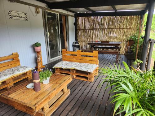 a porch with two wooden benches and a table at Heavenly Stables Self Catering Accommodation in Port Elizabeth